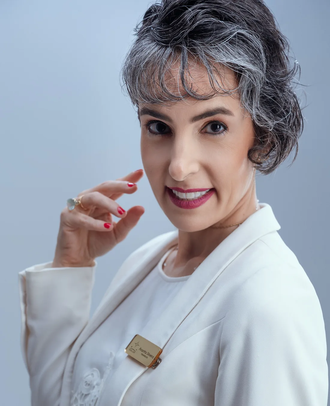 Anaritta Silveira, terapeuta integrativa, de blazer branco, sorrindo